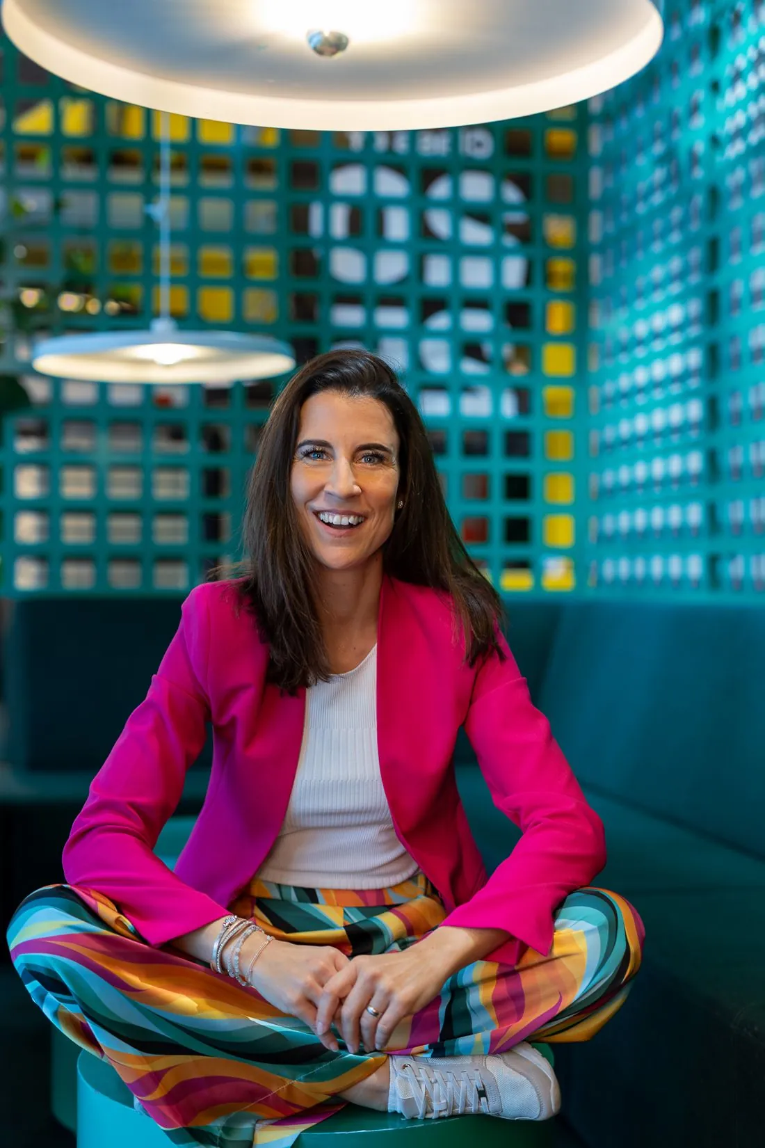 Bettina Binder im pinken Blazer, lachend, Blick in die Kamera